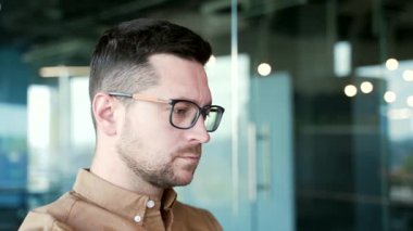 Kapatın. Kendine güvenen bir iş adamı iş yerinde dizüstü bilgisayarda oturuyor. Gözlüklü genç girişimci bir girişim projesi üzerinde çalışıyor. Kodlayıcı bilişim programcısı işiyle meşgul