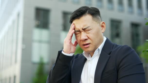 닫으세요 정장에 아시아의 사업가는 사무실 거리에 두통을 느낀다 수컷은 손으로 — 비디오