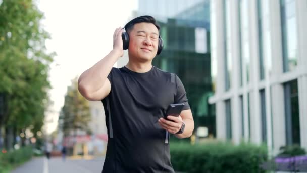 Wesoły Aktywny Azjatycki Facet Sportowy Chodzenie Słuchawkami Telefon Komórkowy Cieszący — Wideo stockowe