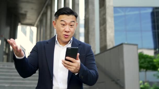 Asijský Podnikatel Slaví Úspěch Přečtení Skvělé Zprávy Smartphone Zatímco Stojí — Stock video