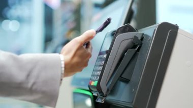 Tezgahtaki Kadın Elektronik Ödeme Süpermarketi akıllı telefonu elinde cep telefonuyla yakın plan kadın eli mağazalardaki temassız NFC Terminal Kapatma kartı okuyucuları için ödeme yapıyor.
