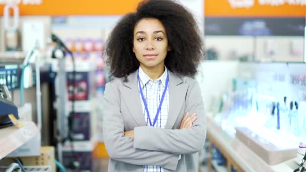 カメラを見ている家庭電化製品店に立っている女性セールスコンサルタントの肖像画 アフリカ系アメリカ人の黒人女性労働者の笑顔 職場のセールスマネージャーベンダー — ストック動画