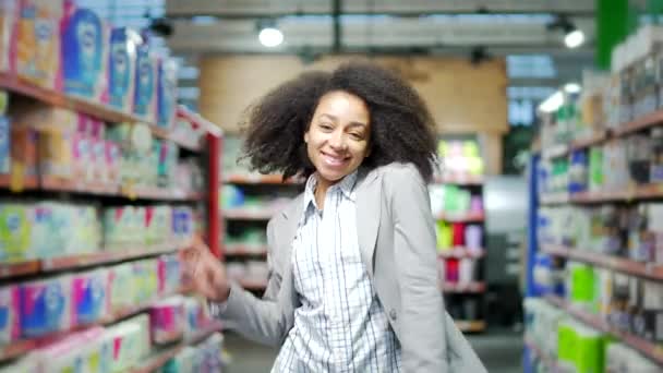 商店里快乐的年轻女性顾客在超市里的一排排间跳着滑稽的舞步 一边在超市里走来走去 一边跳舞 一边跳着时髦的女疯狂舞女 玩得很开心 — 图库视频影像