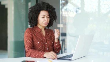 İş yerinde dizüstü bilgisayarla çalışırken göz yorgunluğu çeken çok çalışan Afrikalı Amerikalı genç bir kadın. Siyah kadın göz doktorunun önerdiği görüşü geliştirmek için göz ilacı enjekte ediyor.