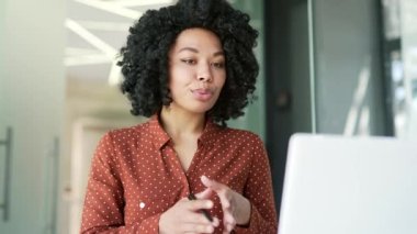 Afrika kökenli Amerikalı bir bayan yönetici iş yerinde oturan bir dizüstü bilgisayarla video görüşmesinde konuşuyor. Siyahi kadın internet konferansında iletişim kuruyor ya da iş ortağıyla sohbet ediyor. Kapat.