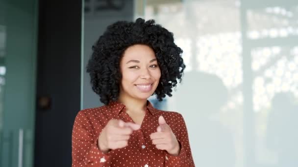 快乐的年轻非洲裔美国女员工站在办公室工作时 手指对着摄像机 微笑积极的黑人女人用双手做出选择的姿态 看着你 — 图库视频影像