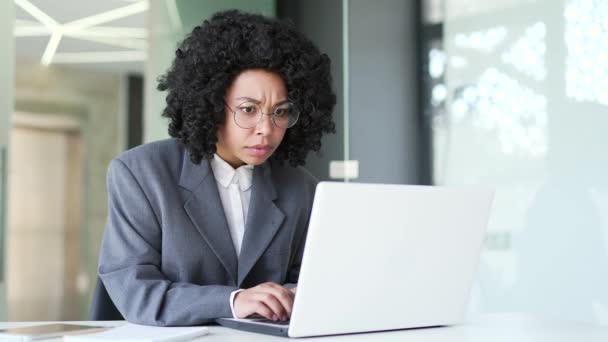 身穿西装的年轻非洲裔美国女商人震惊地在办公室的笔记本电脑上看到了坏消息 黑人妇女对收到的通知或在网上看到的信息感到失望 — 图库视频影像