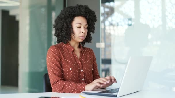 年轻的非洲裔美国女雇员在办公室工作时 在笔记本电脑上工作时出现了恐慌发作 黑人女人感到害怕 呼吸急促 压力很大 被吓到的女人的手指在发抖 — 图库视频影像