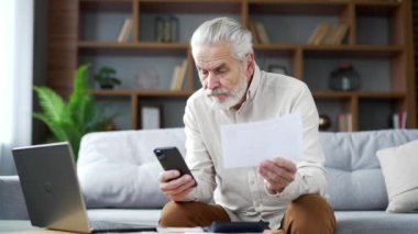 Bilmece gibi yaşlı bir adam evdeki koltukta oturup akıllı telefon kullanarak ev finansmanını hesaplamakta zorlanıyor. Hüsrana uğramış yetişkin bir erkek evrak işleriyle uğraşırken sorunu anlayamaz.