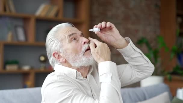 Starší Starší Šedovlasý Muž Trpící Oční Námahou Sedí Doma Pohovce — Stock video