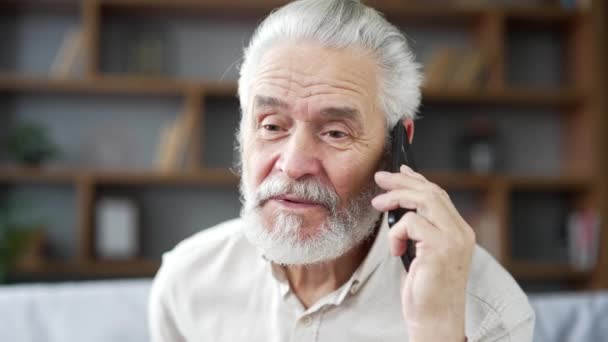 Starszy Starszy Siwy Mężczyzna Rozmawiający Smartfonie Siedząc Kanapie Salonie Domu — Wideo stockowe