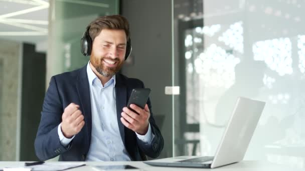 Przystojny Biznesmen Garniturze Bezprzewodowych Słuchawkach Słuchający Muzyki Siedzącej Biurze Szczęśliwy — Wideo stockowe