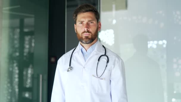 白いコートの真剣な医師は 交差した腕 Xサイン 現代の病院の診療所に立っている間 頭を揺さぶります 医師の医師は禁止 意見の相違のジェスチャーを示しています — ストック動画