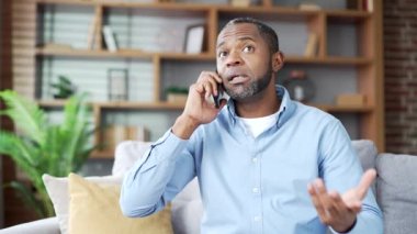 Kendinden emin, Afro-Amerikan bir adam akıllı telefonuyla konuşuyor. Oturma odasındaki kanepede oturuyor. Kıdemli sakallı girişimci bir konuşma yapar, bir iş ortağı veya müşterisiyle iletişim kurar.
