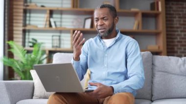 Olgun Afro-Amerikan erkek, evdeki kanepede oturan bir psikolog ya da doktorla görüntülü konuşma yapıyor. Üst düzey siyahi adam internet danışmanlığında hastalığından şikayet ediyor.