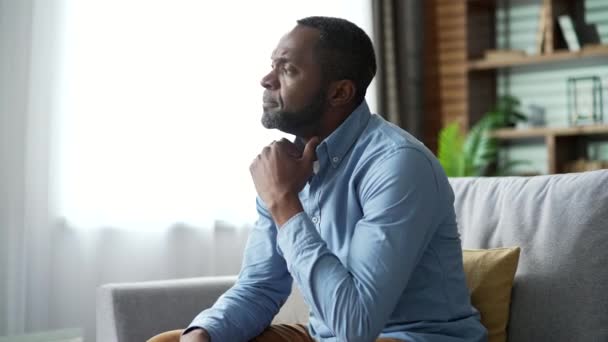 Sylwetka Dojrzałego Afrykańskiego Mężczyzny Czuje Się Przygnębiony Siedząc Kanapie Salonie — Wideo stockowe