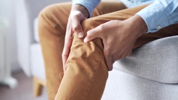 Sluit Maar Mannelijke Handen Masseren Kniebeenspieren Terwijl Bank Zitten Woonkamer — Stockvideo