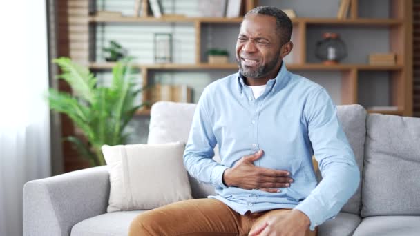 Dojrzały Afroamerykanin Odczuwa Ból Brzucha Siedząc Kanapie Salonie Chory Starszy — Wideo stockowe
