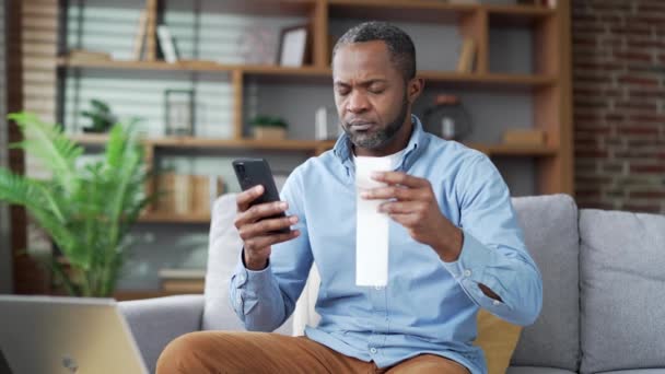 Reifer Afrikanisch Amerikanischer Mann Bezahlt Stromrechnungen Mit Dem Smartphone Das — Stockvideo
