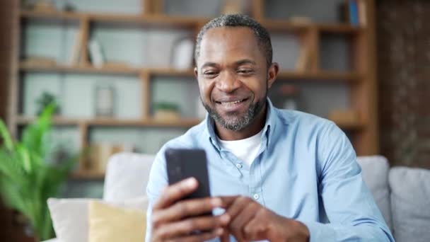 Happy Mature African American Man Received Great News Smartphone Sitting — Stock Video