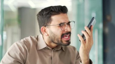 Kızgın hoşnutsuz iş adamı iş yerinde oturmuş akıllı telefondan konuşuyor. Heyecanlı patron, çözülmesi gereken sorunlar hakkında astıyla duygusal olarak konuşur. Kapat.
