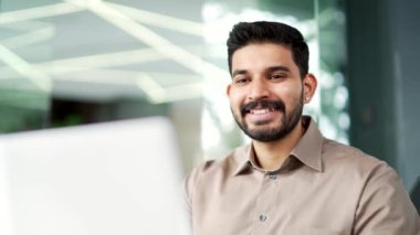 İş yerindeki bir iş yerinde dizüstü bilgisayarda yazan gülümseyen bir iş adamı. Bilgisayar uygulamasında çalışan sakallı bir çalışan, bankacılık, mesajlaşma, internette sohbet. Bir projeyle meşguldüm. Kapat.