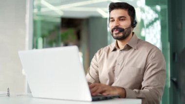 Müşteri desteğinde çalışan bir şirket operatörü bir dizüstü bilgisayar kullanarak bir video görüşmesinde konuşur. Kablosuz kulaklık takmış bir merkez ajanı ofisteki müşterilere şikayette yardımcı oluyor. Çevrimiçi danışma