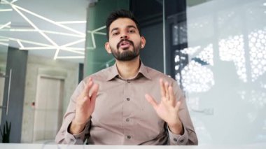 Webcam görüntüsü. İş yerindeki iş yerinde kameraya bakan kendine güvenen bir iş adamı. Erkek antrenör uzaktan konuşur, çevrimiçi bir konferansta veya webinar 'da sohbet eder.