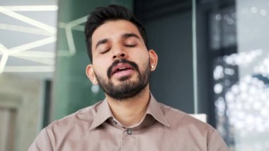 Webcam görüntüsü. Sakallı iş adamı telefonda konuşuyor. Ofiste oturan kameraya bakıyor. Kendine güvenen yakışıklı girişimcinin iş görüşmesi var. İnternet konferansında uzaktan konuşuyor. Kapat.