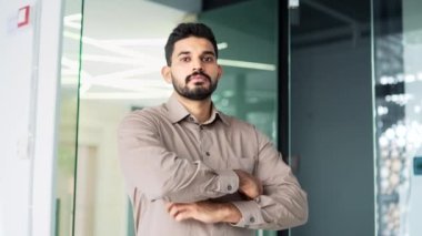 İş yerinde kollarını kavuşturmuş gömlekli ciddi sakallı bir girişimcinin portresi. Kameraya bakarak poz veren başarılı bir iş adamı. Yakışıklı çalışanın ya da müdürün vesikalığı.