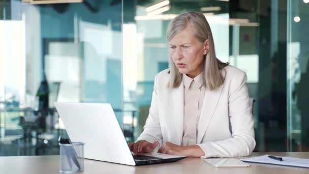 Empört Liest Eine Ältere Grauhaarige Geschäftsfrau Anzug Laptop Arbeitsplatz Büro — Stockvideo