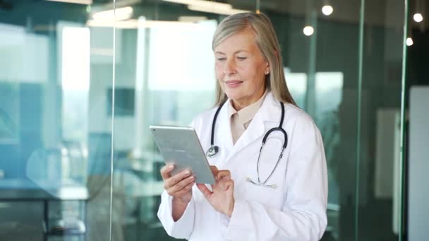 Ősz Hajú Doktornő Fehér Köpenyben Digitális Tablettel Kórházi Klinikán Idős — Stock videók