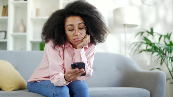 Одинокая Грустная Молодая Африканка Американка Скучает Используя Смартфон Сидя Диване — стоковое видео