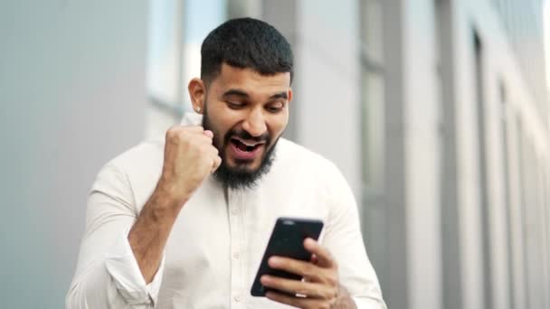 Podekscytowany Szczęśliwy Pracownik Świętuje Sukces Czytając Wspaniałe Wiadomości Przez Telefon — Wideo stockowe