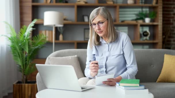 Senior Gray Haired Female Listens Online Learning Using Laptop While — Stock Video
