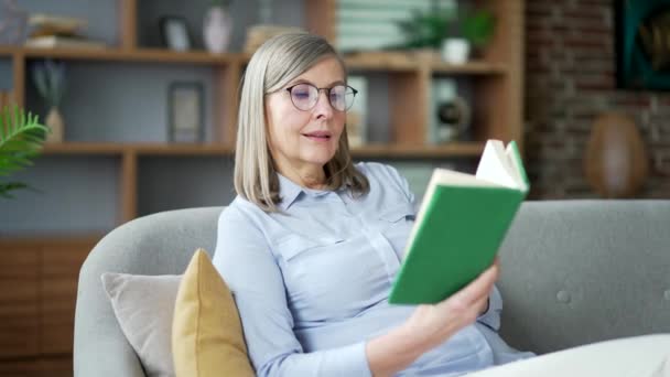 Gelukkige Oudere Seniorengrijze Vrouw Die Boek Leest Terwijl Bank Zit — Stockvideo