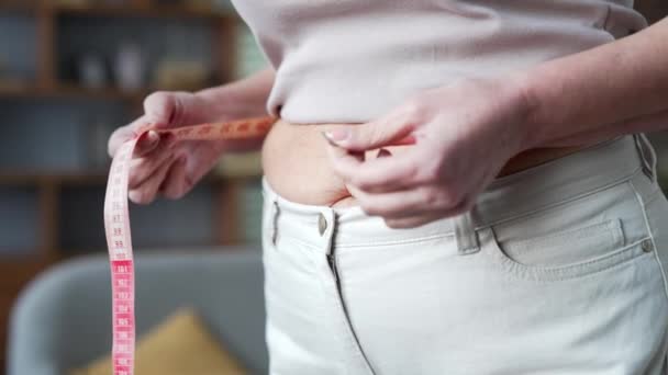 닫으세요 과체중 여성은 테이프로 허리를 측정합니다 그녀의 체중과 다이어트 건강에 — 비디오