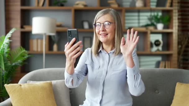 Starsza Siwowłosa Kobieta Rozmawiająca Przez Telefon Robiąca Selfie Kanapie Salonie — Wideo stockowe