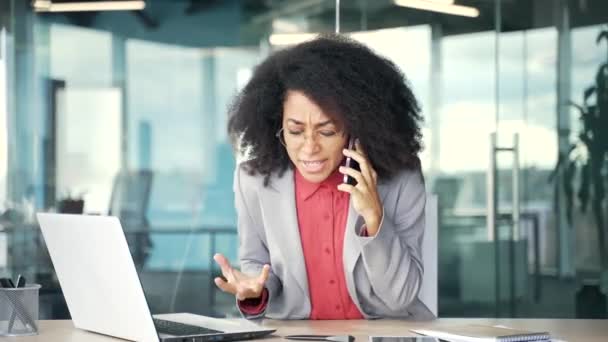 Wściekła Afrykańska Biznesmenka Kłócąca Się Przez Telefon Komórkowy Siedząc Biurze — Wideo stockowe