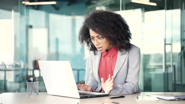 年轻的非洲裔美国女商人坐在办公室工作时 在笔记本电脑上看到了坏消息 这让她很震惊 黑人妇女对信息 收到的通知或在网上看到的东西感到失望 — 图库视频影像