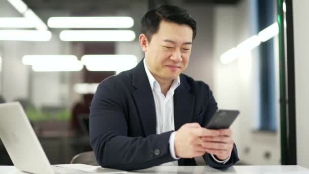 Счастливый Азиатский Бизнесмен Пользуется Телефоном Сидя Рабочем Месте Бизнес Офисе — стоковое видео