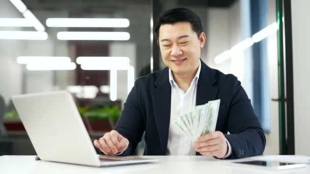 Asiatischer Geschäftsmann Anzug Mit Einem Fan Von Bargeld Dollarscheinen Und — Stockvideo