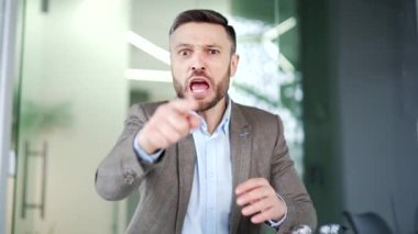 Webcam görüntüsü. Kızgın hoşnutsuz işadamı iş yerindeki iş yerinde kameraya bakarak bir video görüşmesinde tartışıyor. Takım elbiseli heyecanlı bir adam patron, bir astıyla sorunlar hakkında tartışıyor.