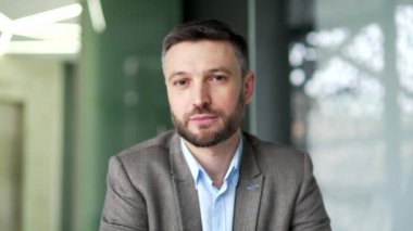 İş yerindeki bir iş adamının portresi. Kameraya bakarak poz veren kendinden emin başarılı bir işçi. Yakışıklı sakallı menajerin ya da patronun vesikalığı. Kapat.