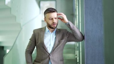 Baş ağrısından muzdarip çok çalışan iş adamı koridorda ya da modern iş merkezinin koridorunda duruyor. Sinirli işçi elleriyle şakaklarına masaj yapıyor. Adam bitkin ve yüksek tansiyonu var.