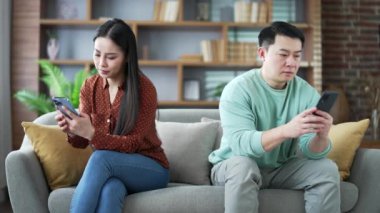 Asyalı karı koca, birbirlerine gücenmişler, evdeki koltukta yan yana otururken cep telefonlarına bakıyorlar. Evli bir çiftin anlaşmazlığı. Sorun, aile ilişkilerinde kriz