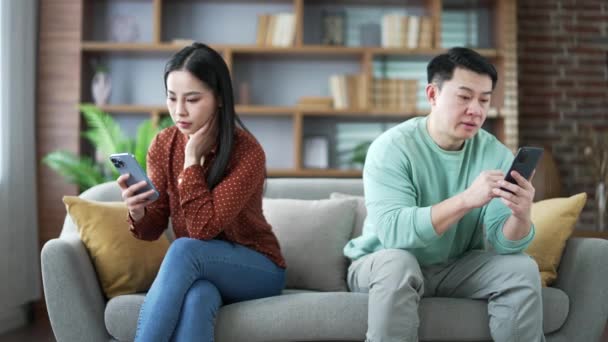 Azjatycka Żona Mąż Znudzeni Patrząc Swoje Telefony Komórkowe Siedząc Obok — Wideo stockowe