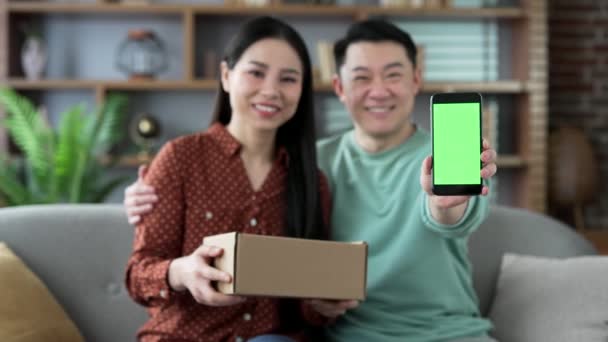 Gelukkig Aziatisch Getrouwd Stel Toont Mobiele Telefoon Met Groen Scherm — Stockvideo