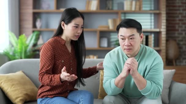 Irritada Esposa Asiática Discutindo Com Marido Sentado Sofá Sala Estar — Vídeo de Stock