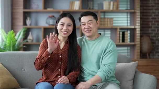 집에서 거실에서 소파에 앉아있는 카메라를보고 통화에 이야기 행복한 아시아 사랑하는 — 비디오